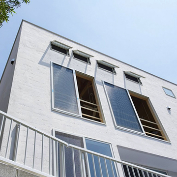 小窓が並ぶ白壁のファサード