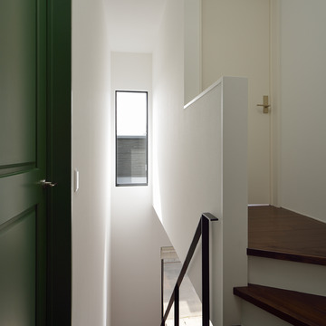 白、緑、焦げ茶のカラーバランスが絶妙な吹抜けの階段