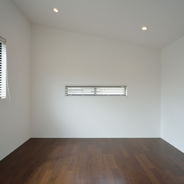 広がりのある勾配天井のシンプルな寝室