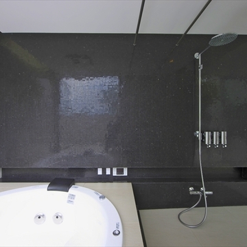 黒いタイルが印象的な浴室
