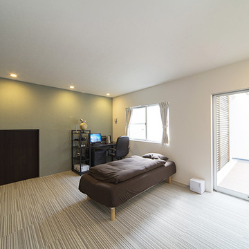 薄いグリーンの壁が落ち着きを放つ寝室