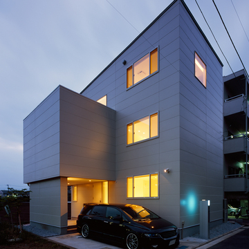 無駄のないシンプルな白い外壁に、優しい電球色の光であふれている夕方の外観