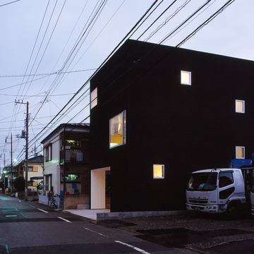 真っ白な額縁のような窓から、優しいオレンジの光に変わる夕方の外観