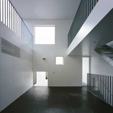 大きめの黒タイルと金属を用いた手すりと階段が、まるで美術館のようなリビングダイニング