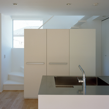 シンプルな階段を、デザイン性の高いキッチン収納で隠したキッチン周り