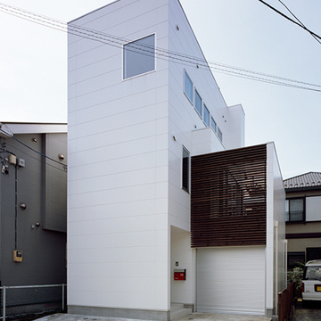 白い外壁に木の格子が美しい外観