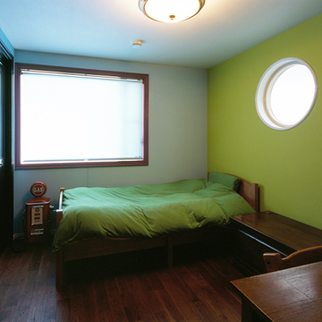 丸く開いた窓が楽しい寝室