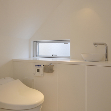 スポットライトの明かりを利用し空間に重点を置いた、隠れ家のような落ち着きのあるトイレ