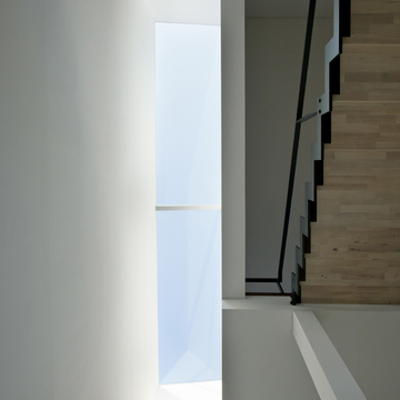 階段室からリビングに連続する壁面を美しく照らすトップライト