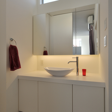 上部に設置された窓から光を取り込む、シンプルな洗面所周り