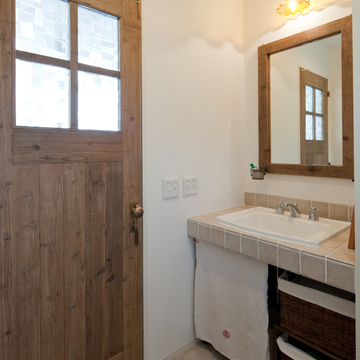 輸入洗面器とタイル、建具と鏡の枠は古木を再利用して作られた一品物と、こだわりぬいた洗面所