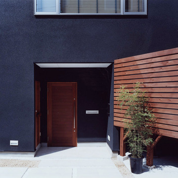 黒い壁に木目が映える玄関アプローチ
