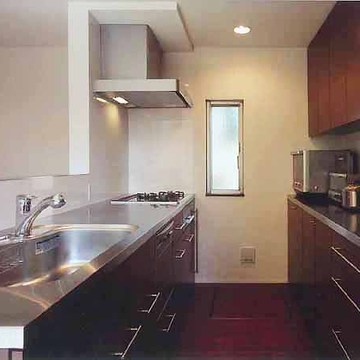 ステンレス素材と焦げ茶の木目で統一した、清潔感あるキッチン