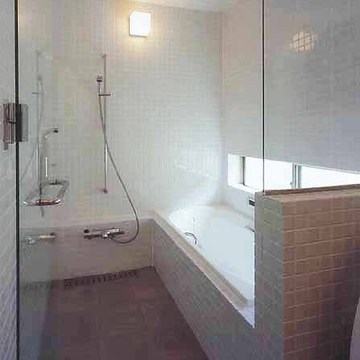 壁面からタイルを使用し、清潔感のあるシンプルな浴室