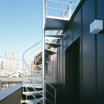 ハードな印象がマッチしている、黒のガルバリウム鋼板の外壁とシルバーカラーの外部階段