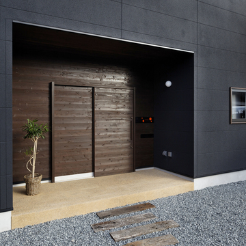 庇代わりに玄関を建物からセットバックさせた、引き戸が似合う外観