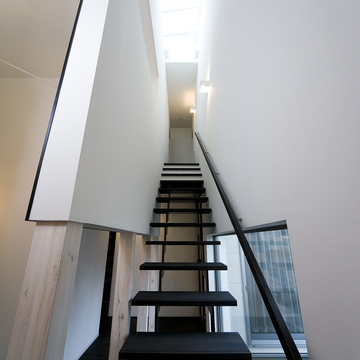 白い空間に、緩やかな川が流れるような美しさのある黒い階段