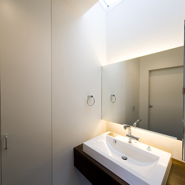 天井からの光、アッパー＆ダウン照明がふんわりとした空気を生むシンプルな洗面所