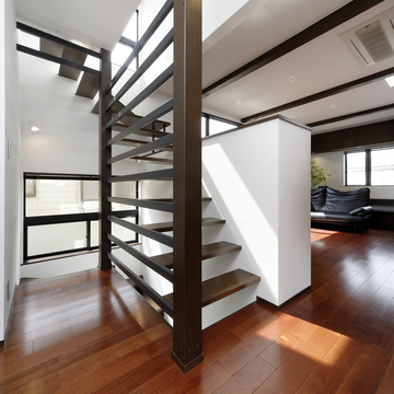 片側の壁面をスポーク上にした、躍動感溢れる階段