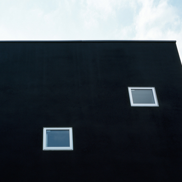 真っ黒な壁面に、小さなスクエア窓がかわいらしく配置する
