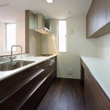 収納とキッチンの色合いをまとめ、ごちゃつきがちなキッチンを美しく見せる