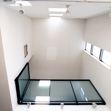 トップライトから入る四角い光が、真っ白な空間にうっすらと映しだされる吹き抜け