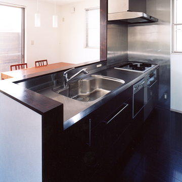 シックな焦げ茶色とステンレスカラーでまとめた、動きやすいキッチン