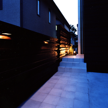 外壁の焼杉の素材感、玄関ホールまで続く柔らかい光が、日本の美を感じるアプローチ