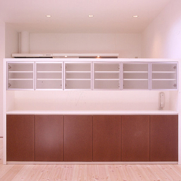 天井高まで仕切らずに家族の声を楽しみながら料理が作れるようにした、壁代わりの造作食器棚