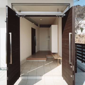 観音開きに開く玄関ドアと、縁側のように癒される広さのある玄関ホール