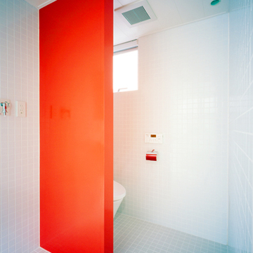 インパクトのある朱い壁が特徴の水まわり