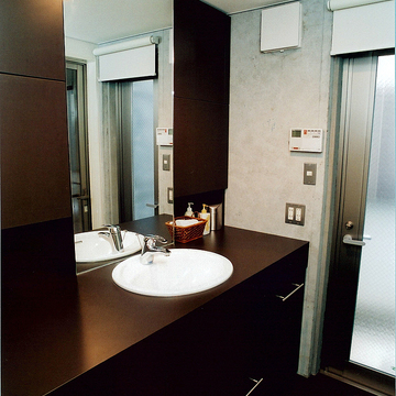 黒でまとめた大人の空気が漂う、コンクリート壁とマッチした洗面所