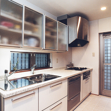 吊り戸収納扉にフロストガラスを使用した、大きめのシンクが料理をしやすいキッチン