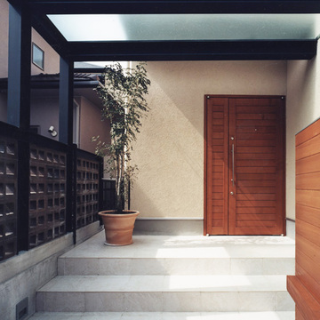 フロストガラスを使用した屋根から、柔らかい光が住人をエスコートする、風と光に満ちた玄関アプローチ