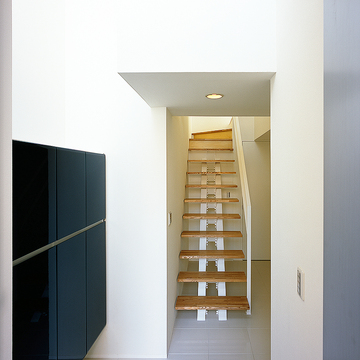 白い壁に、そっと寄り添うように配置されたシンプルな階段