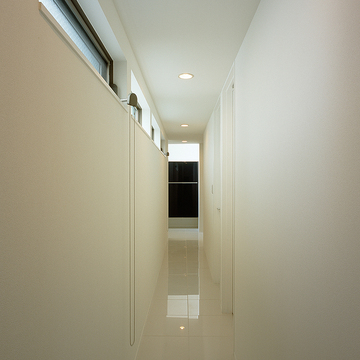 ハイサイドウインドウから柔らかな光が、真っ白にまとめた壁と輝きのある廊下をより美しく見せる