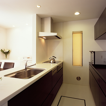 白と焦げ茶でトラッドなテイストでまとめた、無駄のないシンプルなキッチン