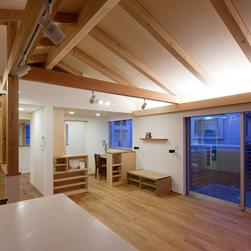 斜め天井を照らすカーテンボックスも兼ねたリビングの間接照明