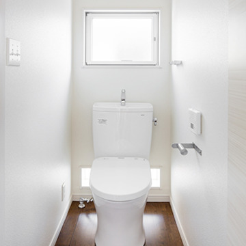 窓からやわらかな日差しが入る白で統一したトイレ