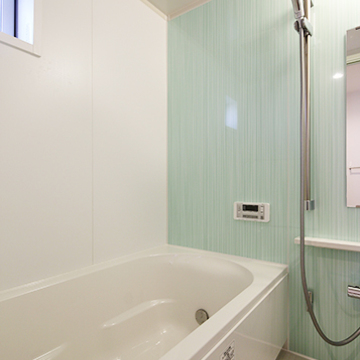 パステルグリーンの壁が爽やかなバスルーム