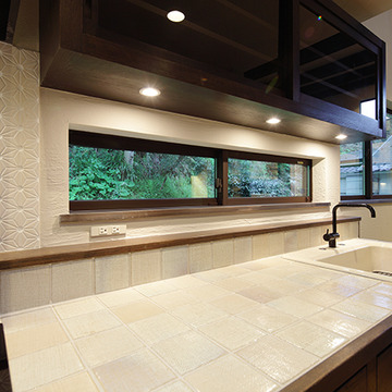 横長の引き違い窓に面したキッチン