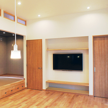 キッチンからこあがりのあるリビングを眺める