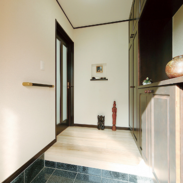 光沢感のある石のタイルが迎える玄関