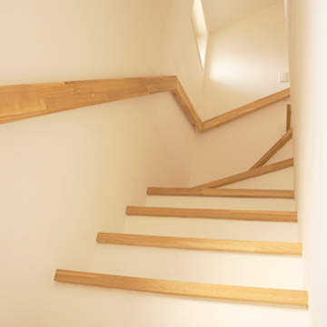 壁面に木の手すりをつけた階段