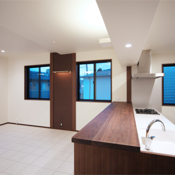 白いキッチンに木目のカウンターがアクセントに