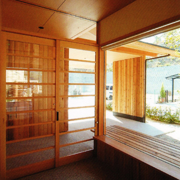 アプローチや中庭との視覚的つながりを強調した玄関
