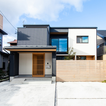 白と黒のシックな外観に木製格子戸がアクセント