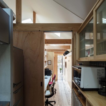 キッチン、事務所、玄関土間のつながり。事務所の床は土足利用も想定して杉足場板。