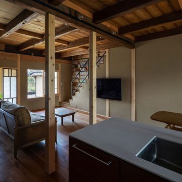 キッチンから玄関・リビングを見る。新しい間取りに合わせて柱を盛り替え。2階の荒板は一度全て剥がして美装し、不陸を調整して貼り直し。その上に構造用合板で補強。