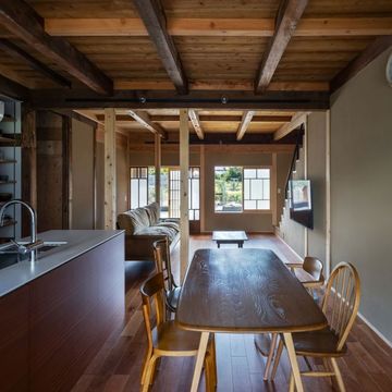 ダイニングから玄関方向。床はチェリー。キッチン面材はサペリ。濃い古材と白い新設材を中間色で取り持つ。